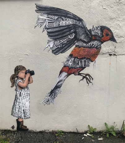 Street art depicting a girl photographing a bird