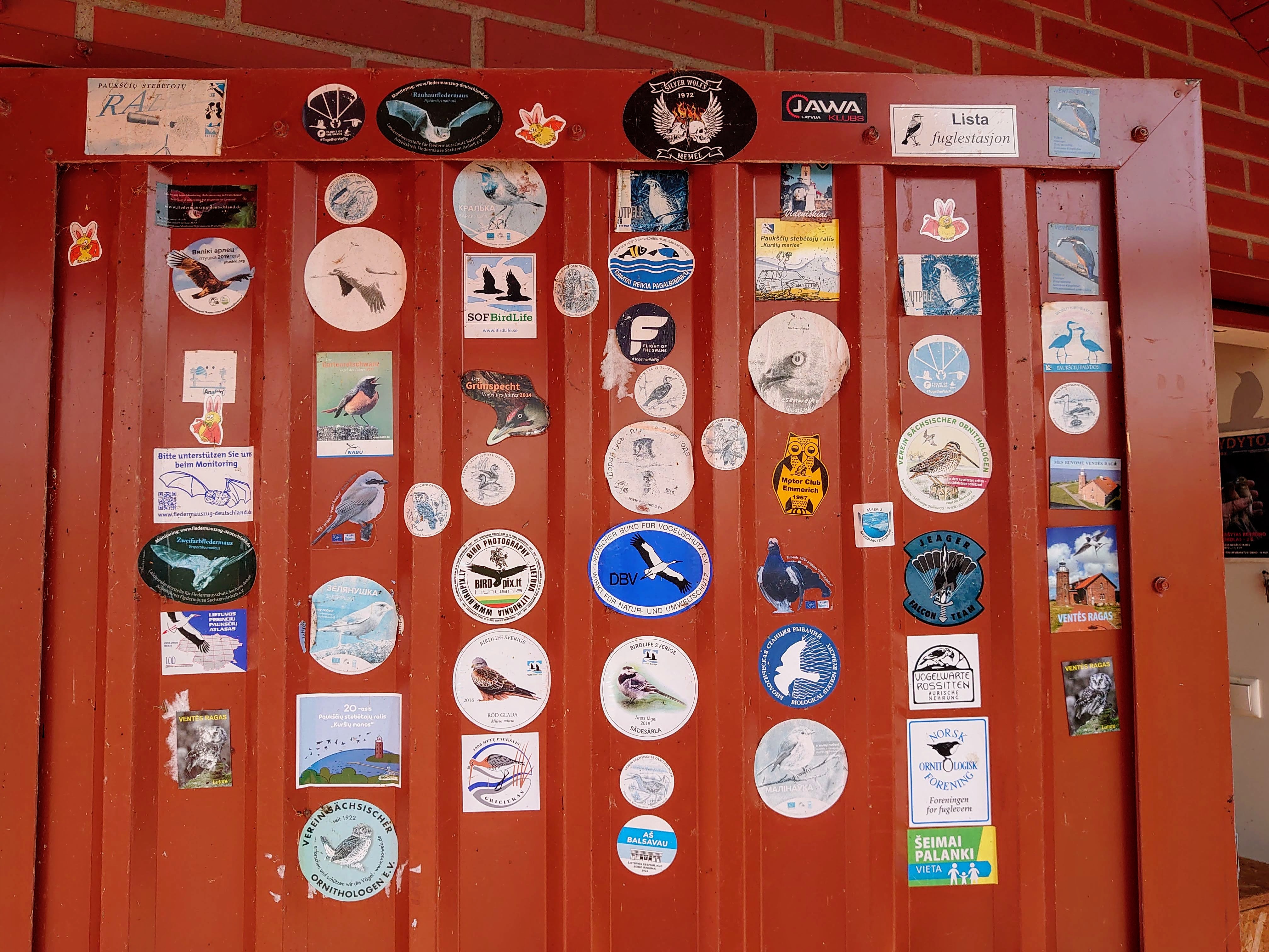 A door at the Ventė Cape Ornithological Station with stickers pasted on it by many birders who have visited.